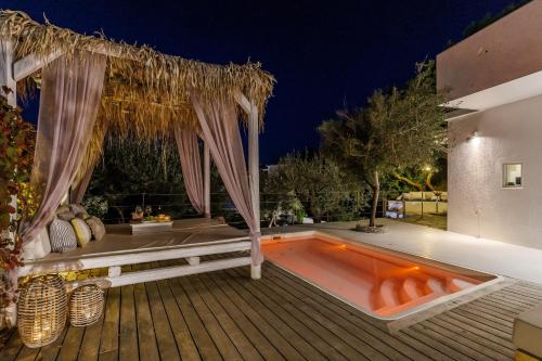 a swimming pool with a pergola on a deck at Evlalia Studios & Villas in Skopelos Town