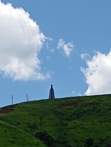 a lighthouse on top of a hill with a blue sky at Casa em Aparecida SP in Aparecida