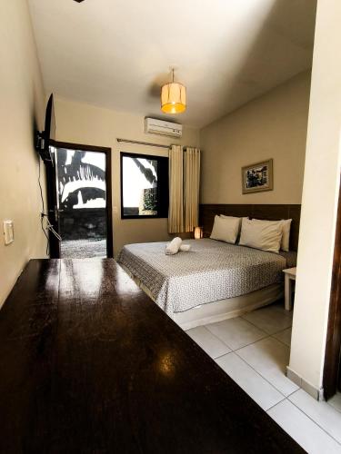 a bedroom with a bed in a room with a window at Pousada Samburá in Barra do Una
