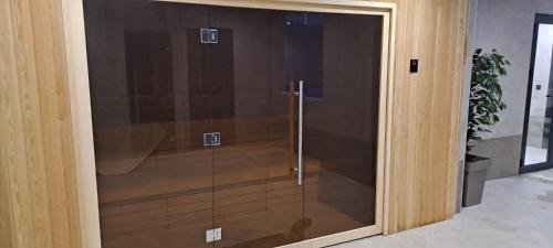 a glass door in a room with a plant at Lawa Apartments Kopaonik in Cajetina