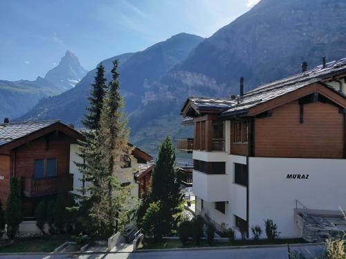 a building with mountains in the background at Modern self-catering apartment with Matterhorn views in Zermatt