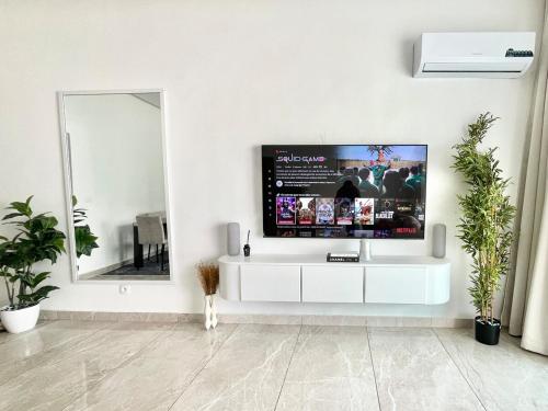 a living room with a tv on a white wall at Jod & Naic Appartement in Abidjan