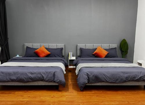 Un dormitorio con dos camas con almohadas azules y naranjas. en New Luxury Semi-D In Banting, Pantai Morib - Nearby Tanjung Sepat, en Banting