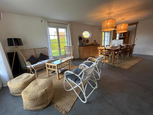 un salon avec des chaises et une table et une cuisine dans l'établissement Villa H, à Hardelot-Plage