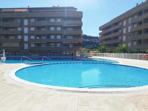 a large swimming pool in front of a building at Moderno apartamento centrico con piscina y parking in Denia