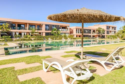 a pair of chairs and an umbrella next to a pool at Maeva cosy - Clim, Wifi, Jardin à 10min de l'Aéroport in Marrakech
