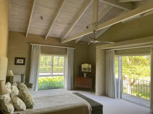 a bedroom with a bed and a ceiling fan at Hartland Country House Luxury Double Rooms in Oudtshoorn