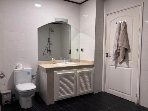Un baño con lavabo, inodoro y espejo. en Rosée Atlantique, en Tamraght Ouzdar