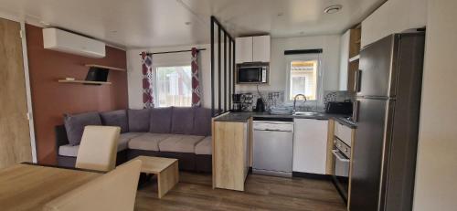 une cuisine et un salon avec un canapé et une table dans l'établissement Mobile home cosy 6 personnes!, à Canet