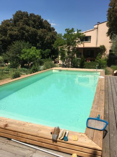une grande piscine avec une chaise et une chaise dans l'établissement A 2 pas du Pont du Gard, à Vers-Pont-du-Gard