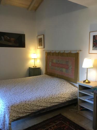 - une chambre avec un lit et deux lampes sur deux tables dans l'établissement A 2 pas du Pont du Gard, à Vers-Pont-du-Gard