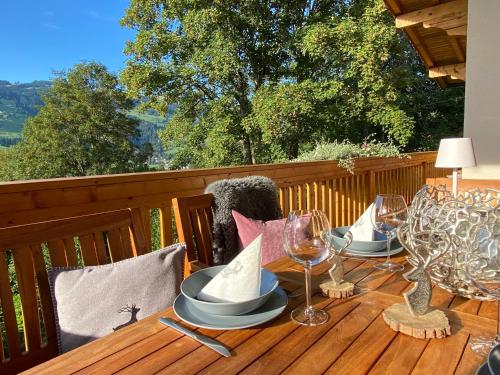 a wooden table with wine glasses and napkins on a deck at Chalet Achenberg in Brixen im Thale