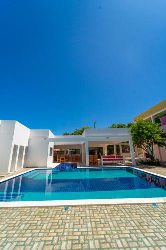 a swimming pool in front of a house at Pousada Cores da Aldeia in Caraíva
