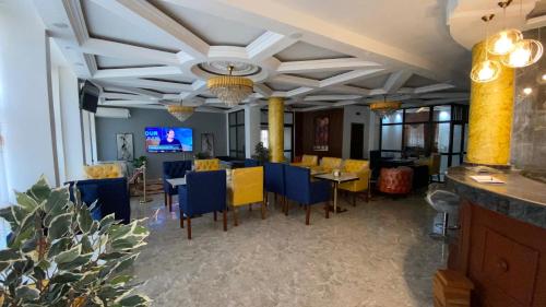 a dining room with blue and yellow tables and chairs at Résidence hôtelière MEDOM Palace, Bastos in Yaoundé