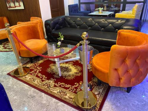 a living room with a couch and orange chairs at Résidence hôtelière MEDOM Palace, Bastos in Yaoundé