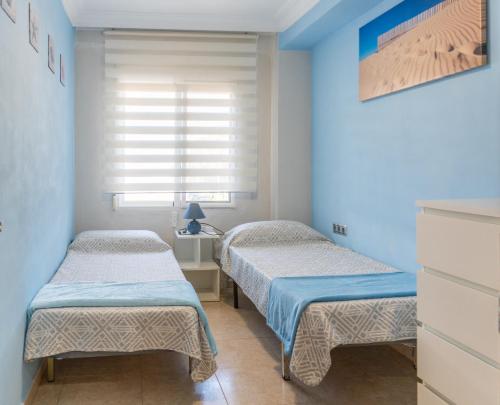 two twin beds in a room with blue walls at New Apartment Alejandro in Torre del Mar
