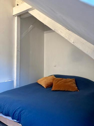 - un lit avec un couvre-lit bleu et un lit en bois dans l'établissement Appartement vieille-ville de Boulogne, vue Cathédrale, à Boulogne-sur-Mer