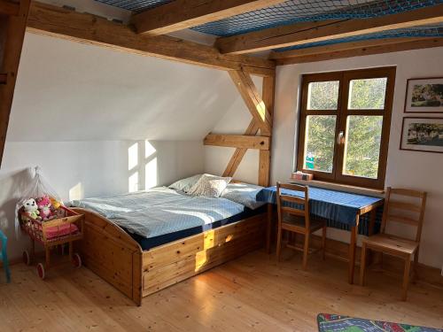 a bedroom with a bed and a table and chairs at Chalupa Ostrůvek in Tachov