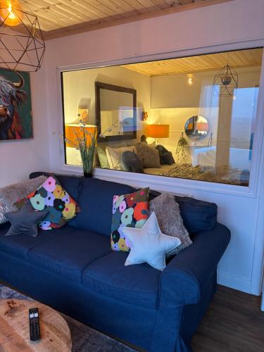 a blue couch in a living room with a large mirror at Bay View Hideaway Lahinch in Lahinch