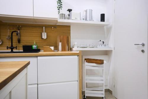 a white kitchen with white cabinets and a sink at The Sweet Spot in Torre del Greco