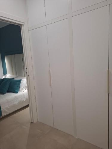 a bedroom with white cabinets next to a bed at The Sweet Spot in Torre del Greco