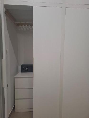 a closet with white walls and a door with a appliance at The Sweet Spot in Torre del Greco