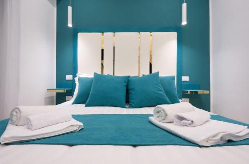 a blue bedroom with a bed with towels on it at The Sweet Spot in Torre del Greco