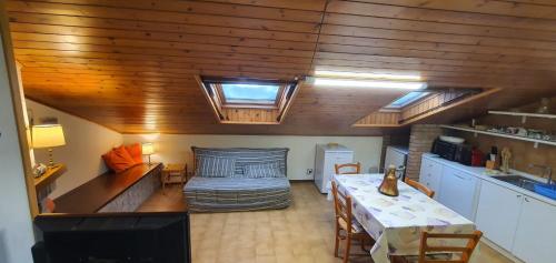 a room with a table and a couch in a room at Mansarda Elena in Sestola