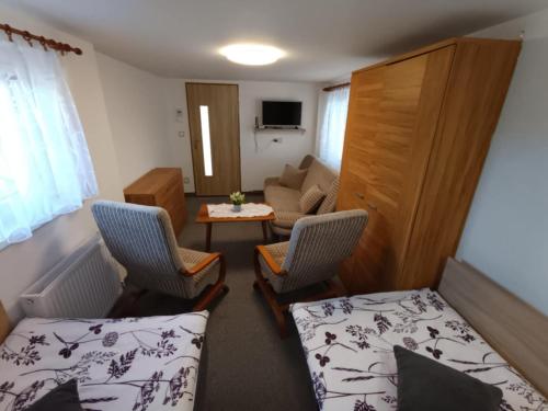 a small room with two beds and a living room at Apartmán Dobrá mysl in Hostinné