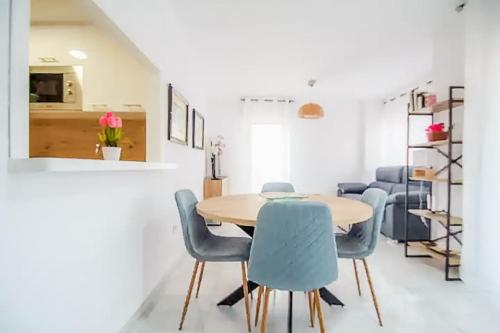 a dining room with a table and blue chairs at Apartment 2 minutes from the beach in Albir