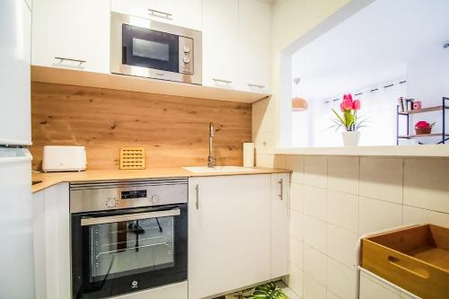 a kitchen with a stove and a microwave at Apartment 2 minutes from the beach in Albir