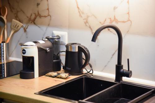 a kitchen counter with a sink and a coffee maker at Finn Modern Seaside Apartment in Durrës