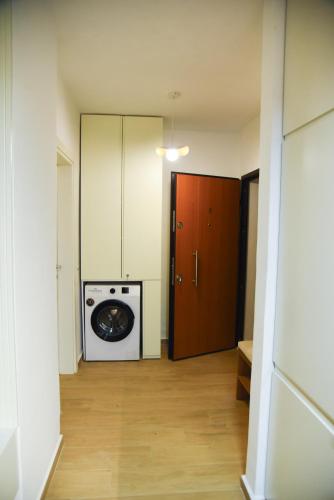 a room with a washing machine and a door at Finn Modern Seaside Apartment in Durrës