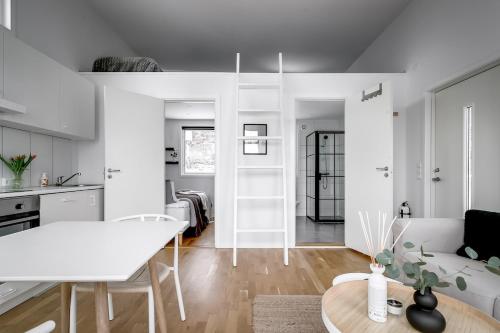 a white kitchen and living room with a white table at 2x Lake House's-Hot Tub-Stunning View-Private Pier in Smidö