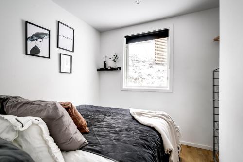 a bedroom with a bed and a window at 2x Lake House's-Hot Tub-Stunning View-Private Pier in Smidö