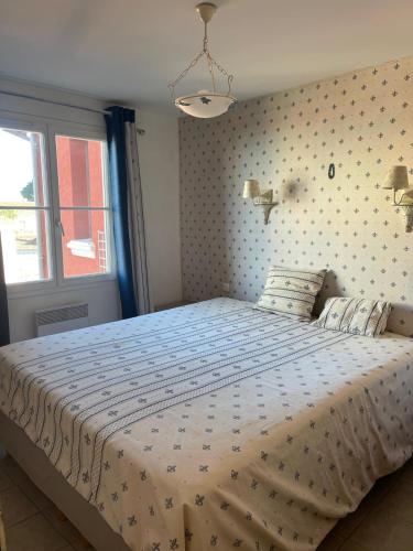 une chambre avec un lit avec une couette blanche dans l'établissement Appartement provençal cœur du village, à Mandelieu-la-Napoule