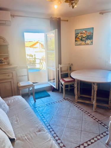 une pièce avec une table, des chaises et une fenêtre dans l'établissement Appartement provençal cœur du village, à Mandelieu-la-Napoule