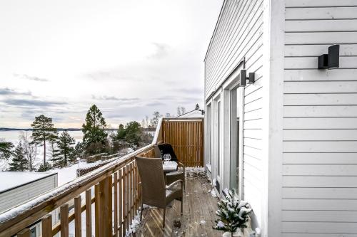 a balcony with a chair and a view of the water at 2x Lake House's-Hot Tub-Stunning View-Private Pier in Smidö