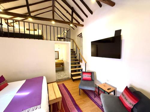 a bedroom with a bed and a tv and a staircase at CASA CRISTOBAL Siete Cuartones in Cusco