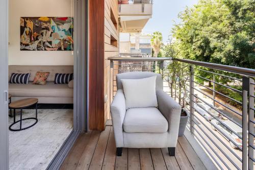 a white chair sitting on a balcony at Luxury Oasis Tel Aviv Beach in Tel Aviv