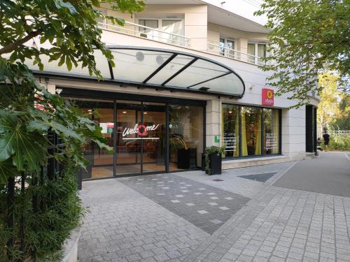 Un frente de tienda de un edificio con una puerta de vidrio en La Défense, Cozy Appartment 2 rooms, en Courbevoie