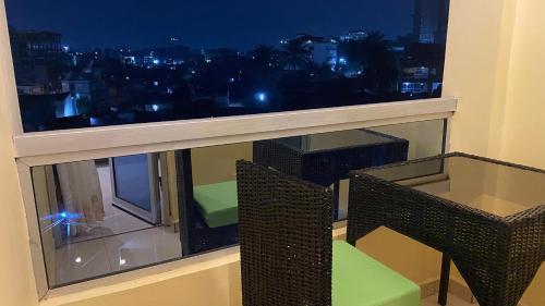 a room with a window with a table and chairs at Résidence hôtelière MEDOM Palace, Bastos in Yaoundé