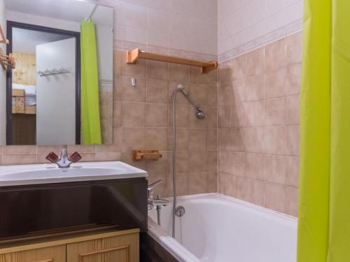 une salle de bain avec un lavabo, une baignoire et un miroir dans l'établissement Studio mezzanine 35m², 6 pers, proche pistes et commerces, balcon, ascenseur, casier à skis - FR-1-275-143, à La Rosière