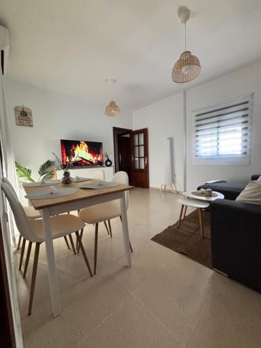 a living room with a table and a fireplace at Casa Azacanes in Sanlúcar de Barrameda