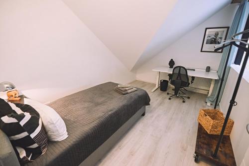 a bedroom with a bed and a desk in a attic at Bildstein's "Kathmandu" in Langenfeld