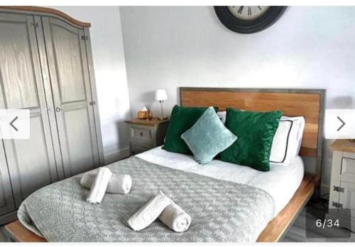 a bedroom with a bed with green pillows at Modern and Luxurious 4 bedroom house in Bangor