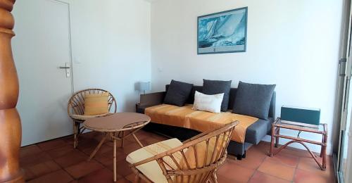 a room with a bed and a couch and a table at La Villa des Dunes bord de mer in Loctudy
