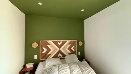 ein Schlafzimmer mit einer grünen Wand mit einem Bett in der Unterkunft T2 neuf centre ville la tour du pin-Clim-parking-gare in La Tour-du-Pin