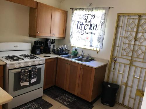 a kitchen with a stove and a sink and a window at Quiet 2 bedroom 2 bathroom Home in Falmouth, Jamaica Parish of Trelawny in Falmouth