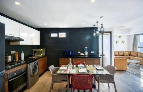 a kitchen with a table and chairs in a room at 2 minutes de la plage , Résidence Tamourrit, Taghazout Bay , vue mer , golf , piscine in Taghazout